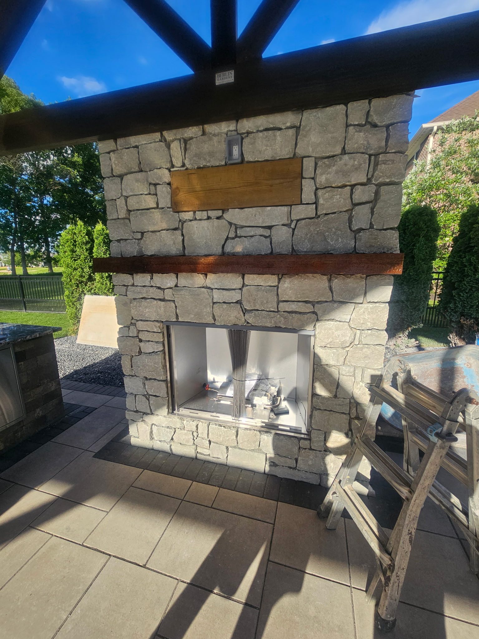 Stone outdoor fireplace by LA Landscapes Inc